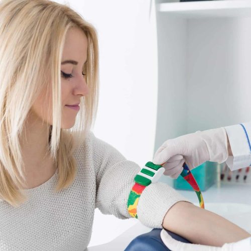 Healthcare professional performing a blood test during a home visit in a comfortable British living room